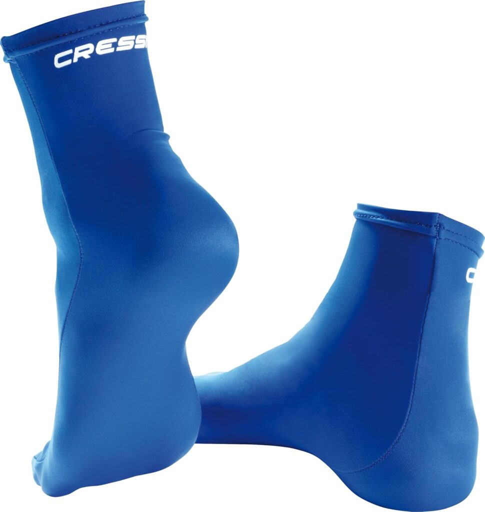A pair of bright blue Cressi lycra dive socks are displayed against a white background. One sock stands upright showing the heel and logo near the top, while the other lies flat, revealing the side profile and seamless design.
